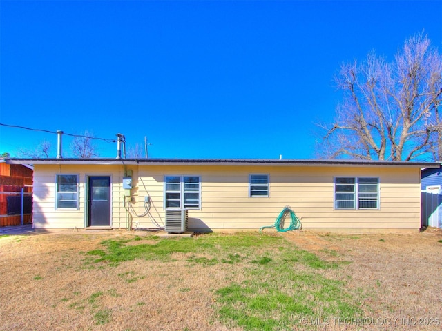 back of house featuring a lawn and cooling unit