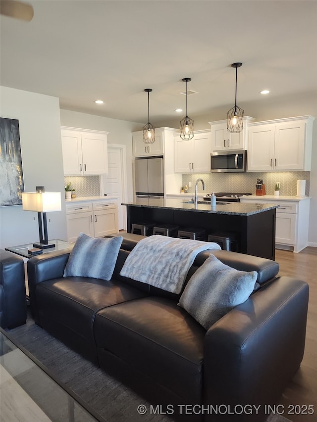 living room with light wood-type flooring, recessed lighting, and visible vents