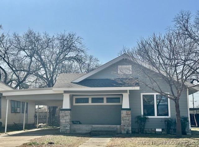 bungalow-style house featuring an attached carport, crawl space, roof with shingles, and driveway