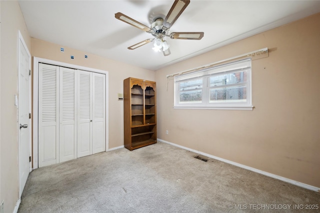 unfurnished bedroom featuring a closet, carpet flooring, visible vents, and baseboards