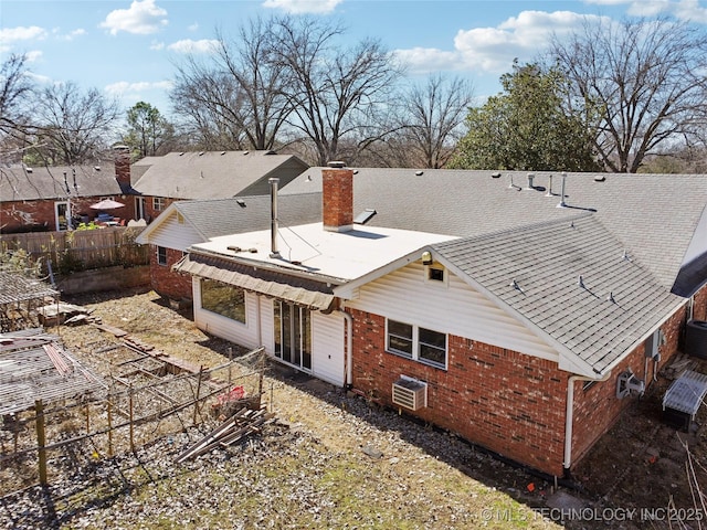 back of house with central AC, brick siding, a chimney, and fence