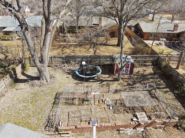 view of yard featuring a garden, an outdoor structure, and a fenced backyard