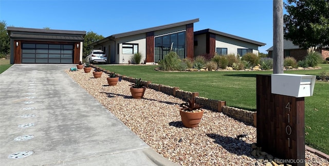 view of front of house with a garage, a front yard, and driveway