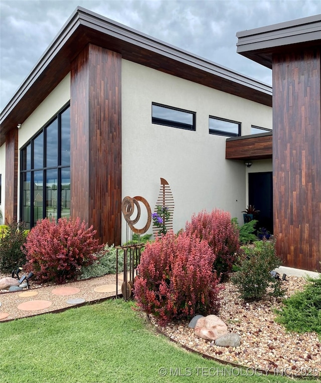 view of side of property featuring a yard and stucco siding