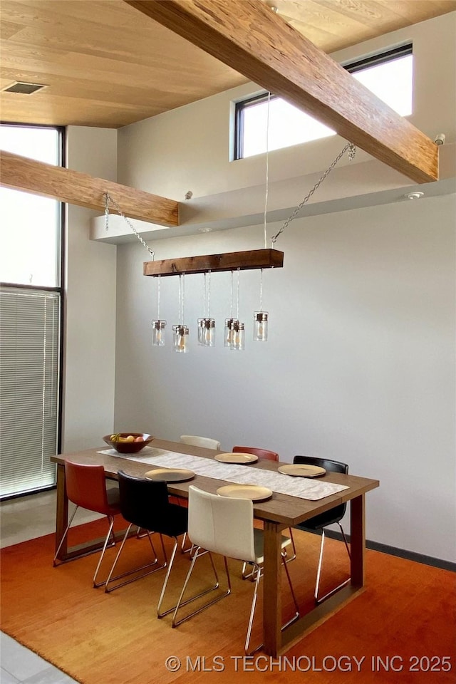 dining room featuring vaulted ceiling with beams, wood ceiling, a wealth of natural light, and wood finished floors