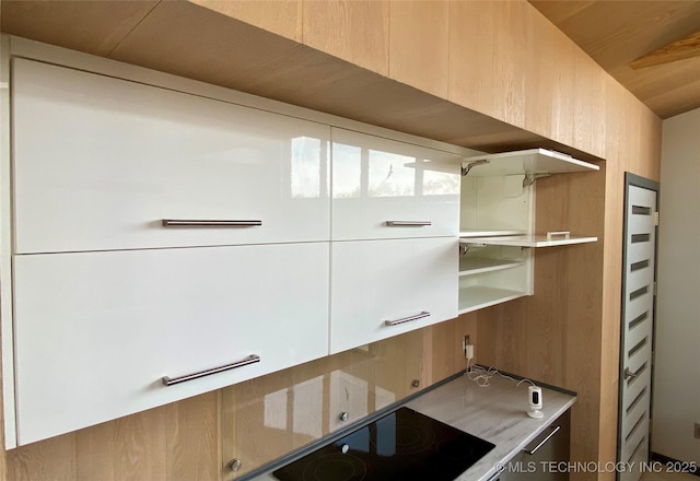 kitchen with light countertops, black electric stovetop, and modern cabinets