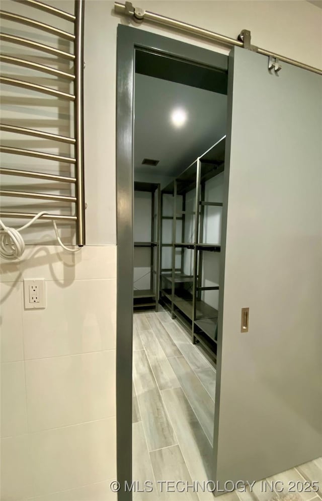 corridor with radiator heating unit, wood tiled floor, and visible vents