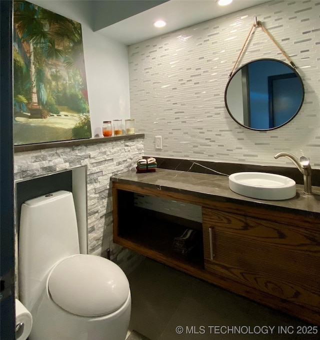 bathroom with recessed lighting, vanity, and decorative backsplash