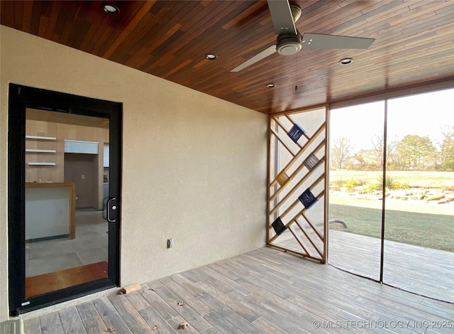 unfurnished sunroom featuring wooden ceiling and a ceiling fan