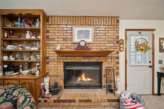 carpeted living area with a textured ceiling and a brick fireplace