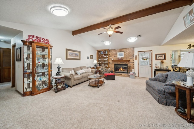 living area with visible vents, lofted ceiling with beams, a textured ceiling, carpet, and a fireplace