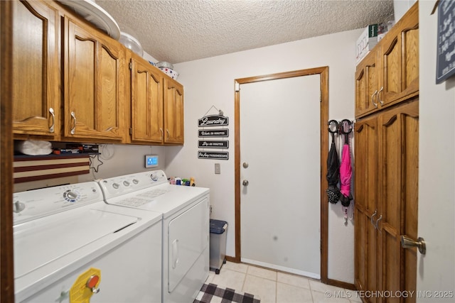 clothes washing area featuring cabinet space, a textured ceiling, light tile patterned flooring, and washer and clothes dryer