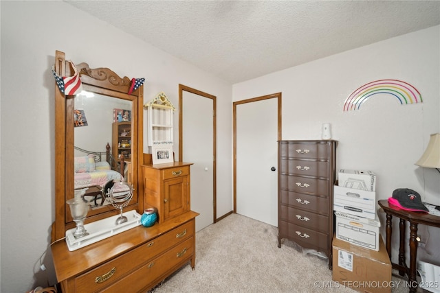 bedroom featuring light carpet and a textured ceiling