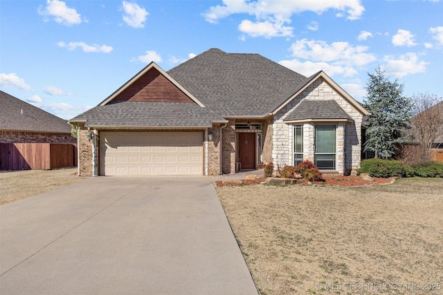 view of front of property featuring driveway, a shingled roof, an attached garage, and fence