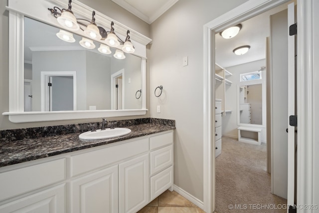 bathroom featuring ornamental molding, vanity, and baseboards