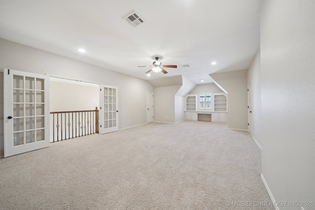 carpeted spare room with baseboards, visible vents, a ceiling fan, built in shelves, and recessed lighting