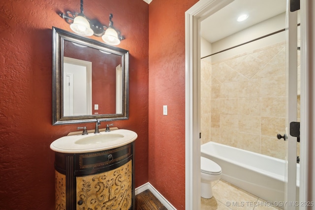 bathroom with shower / bath combination, a textured wall, toilet, tile patterned floors, and vanity