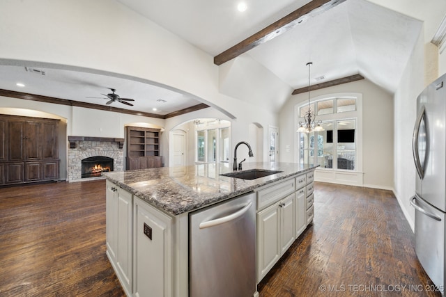 kitchen featuring vaulted ceiling with beams, stainless steel appliances, dark wood-style flooring, a sink, and light stone countertops