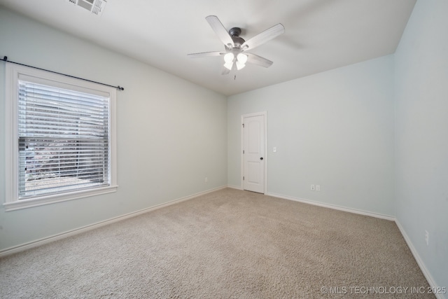 spare room with visible vents, ceiling fan, light carpet, and baseboards