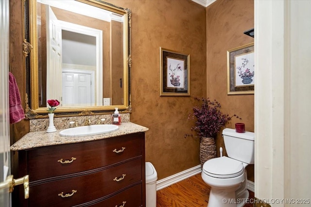 bathroom featuring vanity, wood finished floors, toilet, and baseboards