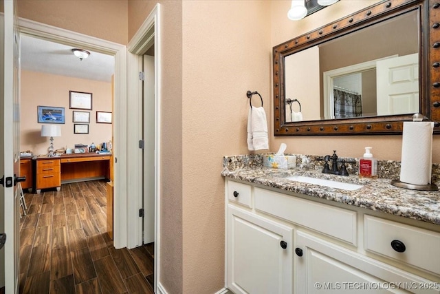 bathroom featuring a textured wall, wood finished floors, and vanity