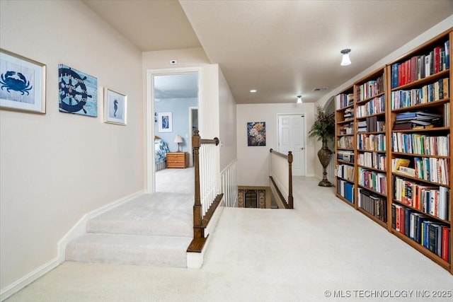 hall featuring visible vents, carpet, an upstairs landing, and baseboards