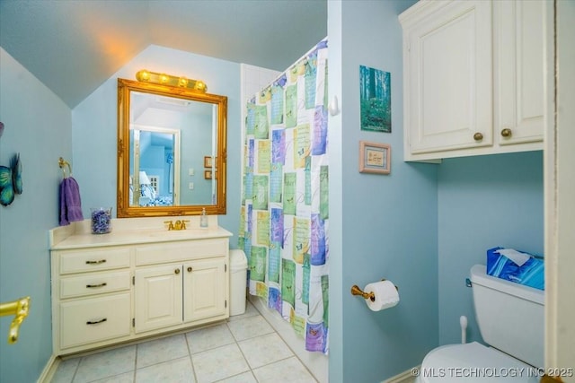 bathroom featuring lofted ceiling, curtained shower, toilet, vanity, and tile patterned flooring