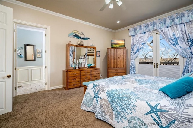 carpeted bedroom with ceiling fan, french doors, ornamental molding, and a decorative wall