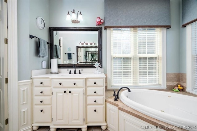 bathroom with a healthy amount of sunlight, a garden tub, and vanity