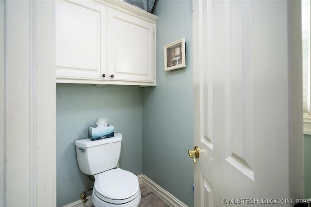 bathroom featuring toilet and baseboards