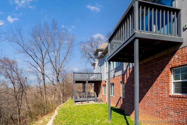 view of side of home featuring a yard and brick siding