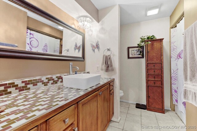 bathroom featuring visible vents, an inviting chandelier, toilet, vanity, and tile patterned flooring