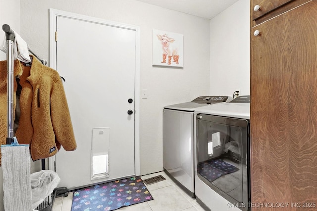 laundry area with light tile patterned floors, laundry area, and washing machine and clothes dryer