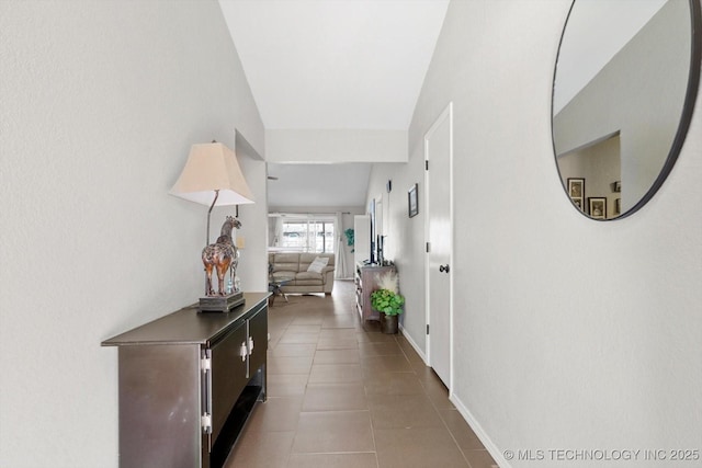 hallway with tile patterned flooring and baseboards