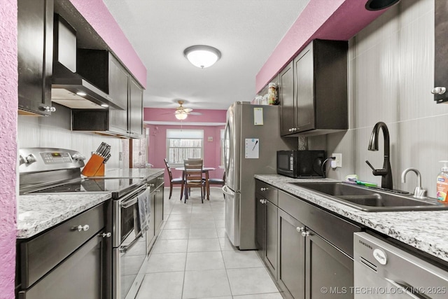 kitchen with light tile patterned floors, tasteful backsplash, a ceiling fan, a sink, and stainless steel appliances