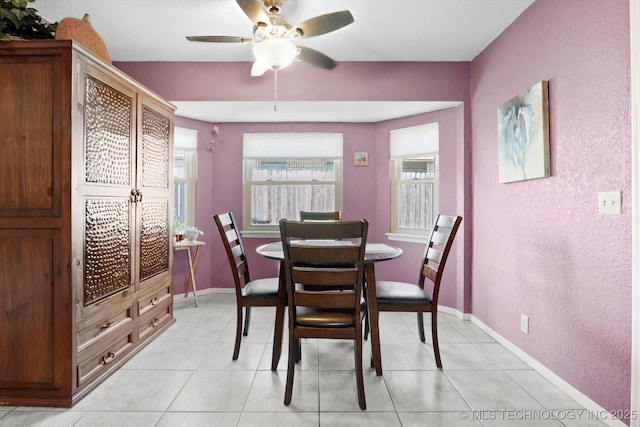 dining space featuring baseboards, a ceiling fan, and light tile patterned flooring