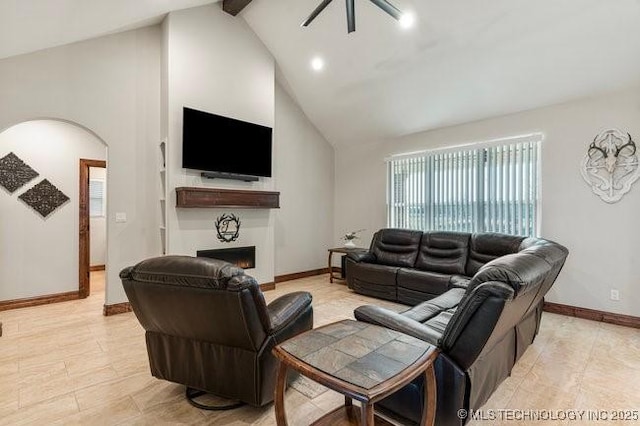 living room with arched walkways, high vaulted ceiling, a warm lit fireplace, baseboards, and beamed ceiling