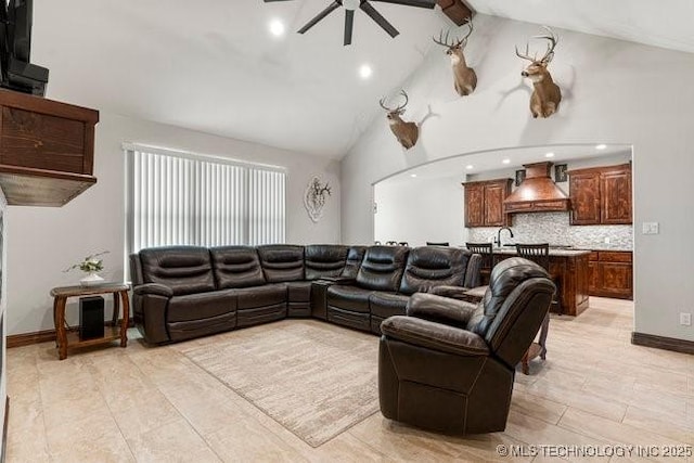 living area with baseboards, ceiling fan, beamed ceiling, high vaulted ceiling, and recessed lighting