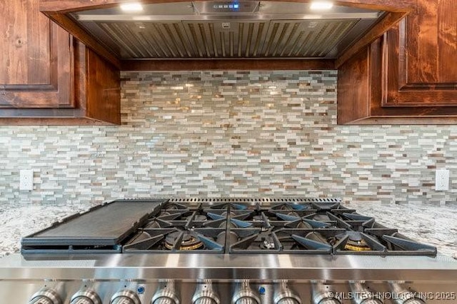 kitchen with custom range hood, backsplash, and gas range oven