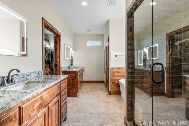 bathroom with two vanities, visible vents, a freestanding bath, a sink, and a shower stall