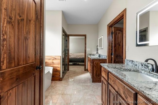 full bathroom with a soaking tub, two vanities, a sink, and ensuite bathroom