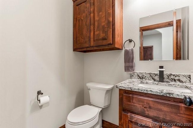 half bathroom featuring vanity and toilet