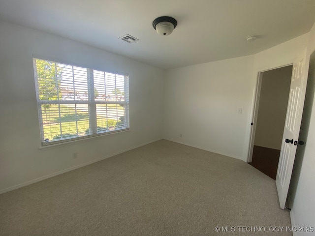 carpeted empty room with baseboards and visible vents