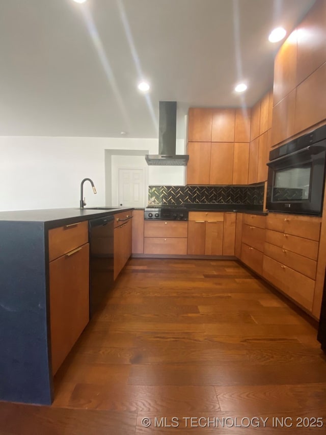 kitchen with cooktop, wall oven, a sink, dishwasher, and wall chimney exhaust hood