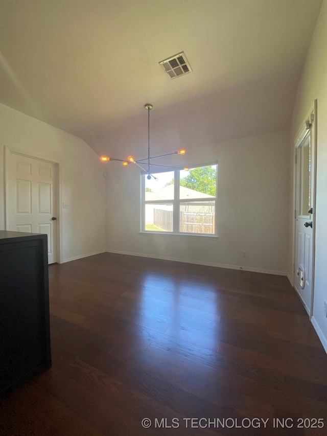 unfurnished room featuring lofted ceiling, dark wood finished floors, visible vents, and baseboards