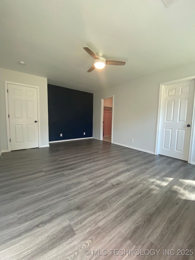 unfurnished room featuring a ceiling fan, baseboards, and wood finished floors