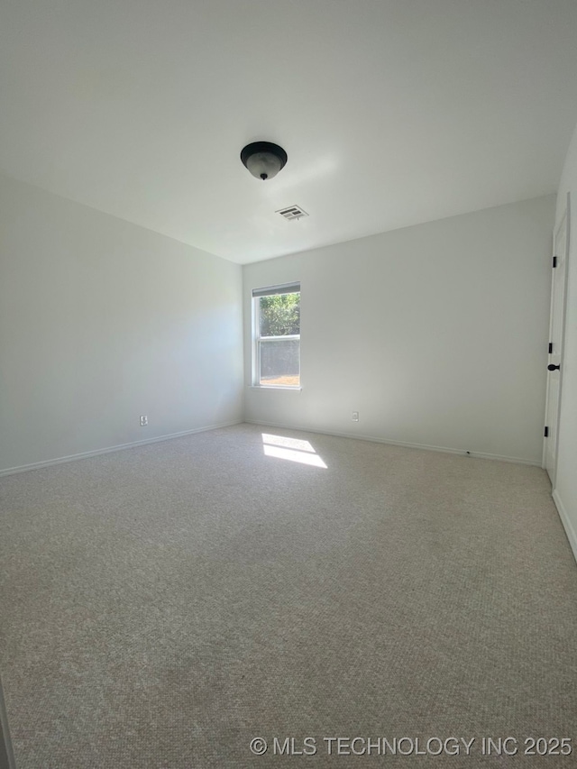 spare room with carpet, visible vents, and baseboards