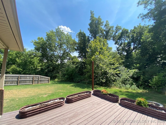 wooden terrace with a lawn and fence