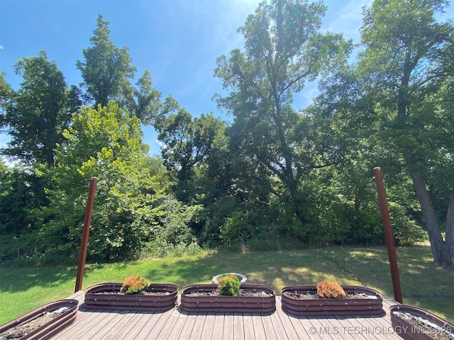 deck with an outdoor fire pit and a lawn