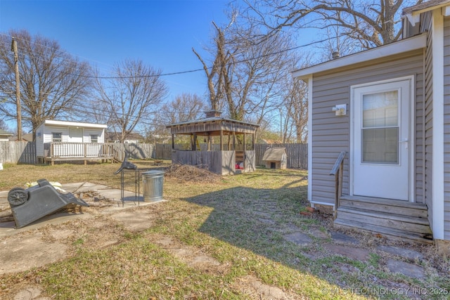 view of yard featuring entry steps, a fenced backyard, and an outbuilding